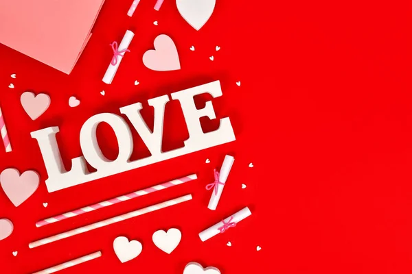 stock image Valentine's Day decoration with love text, heart ornaments and sprinkles on red background with copy space