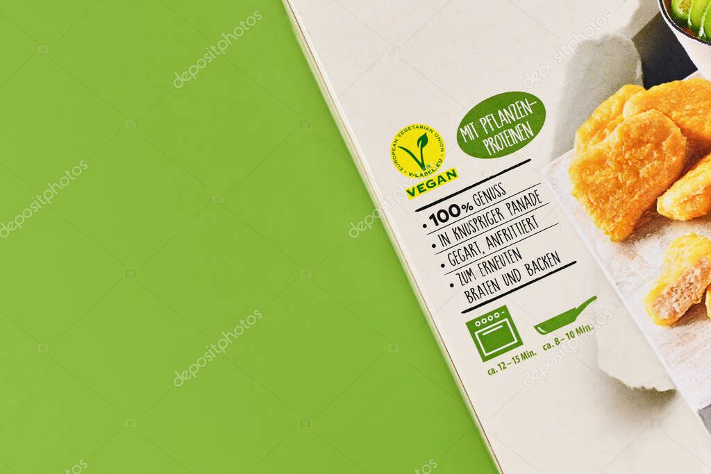 Germany - March 2023: Package of vegan meat substitute food with label and German text on green background with copy space