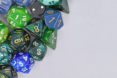 Boş kopya alanı olan gri arkaplan tarafında mavi ve yeşil RPG zarları
