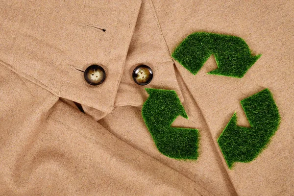 베이지색 코트에 잔디로 화살표 기호를 재활용 친화적 의류에 — 스톡 사진