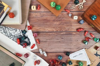 Renkli RPG zarları, kural kitapları ve ortalarında kopyalama alanı olan ahşap arkaplan üzerine notlar içeren düz arkaplan rolü
