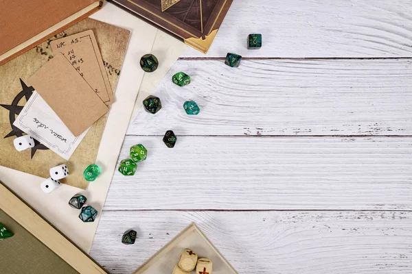 Tabletop role playing flat lay background with RPG dices, rule books, dungeon map on white wooden background with copy space