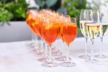 Turuncu Spritz 'li bardaklar. Düğünde restorandaki masada şarap bazlı bir kokteyl.