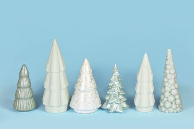 Mavi arka planda farklı şekilli açık yeşil seramik Noel ağaçları