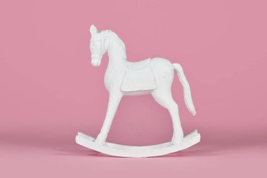 Beyaz ahşap eski tarz sallanan at Noel süsleri pembe arka planda