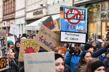 Heidelberg, Almanya - 12 Şubat 2025: Aşırı sağcıları protesto etmek için kalabalık içinde pankart tutan gençler 