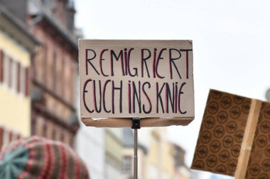 Heidelberg, Almanya - 12 Şubat 2025: Aşırı sağcıları protesto etmek için 'Göçmenlik' tabelasını tutan kişi 