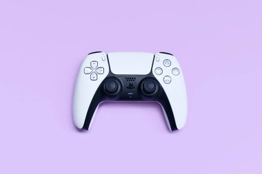 Almanya - Mayıs 2025: Pastel menekşe arkaplan üzerine beyaz PlayStation 5 oyun denetleyici