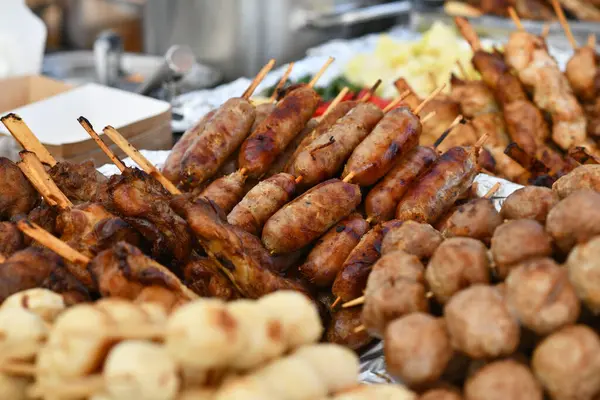 Küçük Thai 'Sai Krok Isaan' ın domuz sosisleri sokak pazarında diğer Tayland yemekleriyle çevrili.