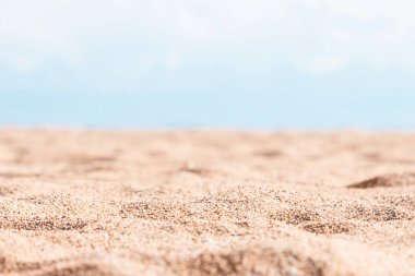 Küçük çakıl taşları olan sarı kumlu güzel bir sahil güneşli bir günde mavi gökyüzüne odaklanmış. Panoramik manzara. Yaz tatili için doğal bir geçmiş. Boşluğu kopyala