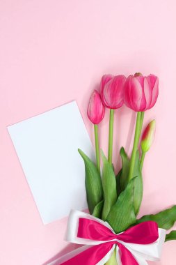 Pembe laleler, fiyonk ve kağıttan bir buket hediye. Uluslararası Kadınlar ve Anneler Günü, doğum günü, Sevgililer Günü, tatil. Boşluğu kopyala
