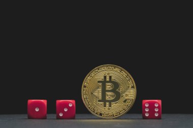 Kripto para birimi riski, Bitcoin bahis ve fiyatı kavramlarını temsil eden kavramsal görüntü. Farklı skorlara sahip üç zarın arasında bir Bitcoin.