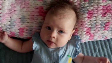 Küçük kız yatakta yatıyor ve elinde bir oyuncak var.