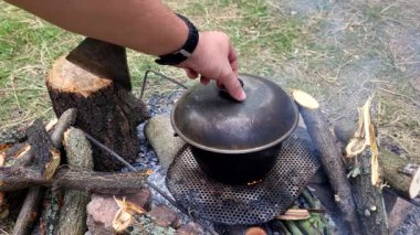 Ormandaki ateşte bir tencere yemek.