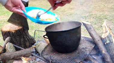 Bir kupa sıcak kahve ve bir kamp ateşinin arka planında ateş.
