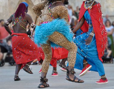 Dansçılar Kenya, Afrika 'dan geleneksel halk kostümlerinden birini giyip dans ediyorlar.