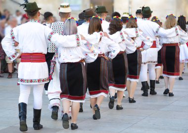 Dansçılar dans ediyor ve Romanya 'nın geleneksel halk kostümlerinden birini giyiyorlar