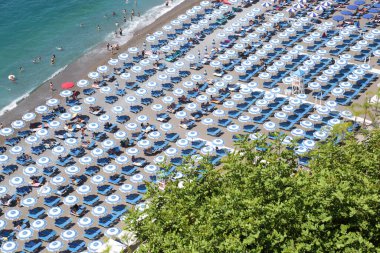 Mavi plaj şemsiyeleri ve İtalya 'nın Amalfi Sahili' ndeki Positano sahilinin kıyıları.
