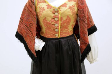 Çiçekli korse, kabarık kollu, kırmızı şallı ve koyu etekli geleneksel Cantabrian kostümü..