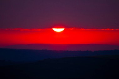Gün batımı manzarası. Renkli ufuk, büyük parlak güneş, güzel doğa.