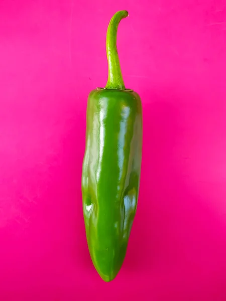 A fresh green pepper isolated on pink background