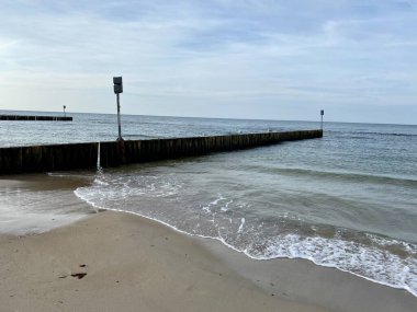 Sahili ve sahili deniz dalgalarından korumak için sıra sıra dizilmiş tahta yığınları.