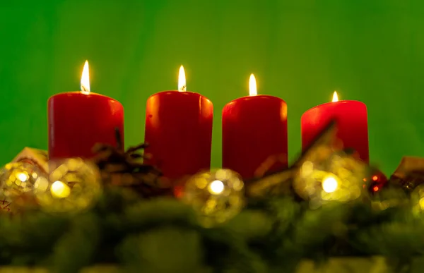 Traditionele Adventskransen Met Vlammen Brandende Kaarsen Voor Een Groene Achtergrond — Stockfoto
