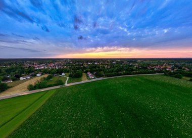 Yeşil Tarlaların ve Uzak Kasabanın Üzerinde Gün Batımı Parıltısı.