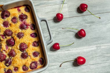 Clafoutis vişneli turta - geleneksel Fransız turtası masanın üstünde, üst tarafta.