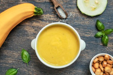 Ahşap arka planda beyaz bir kasede sebze çorbası, üst manzara.