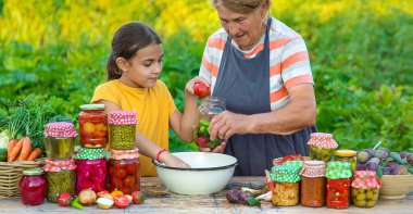 Women with jar preserved vegetables for the winter mother and daughter. Selective focus. Food.