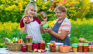Women with jar preserved vegetables for the winter mother and daughter. Selective focus. Food.
