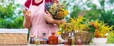 Woman with medicinal herbs and tinctures. Selective focus. Nature.