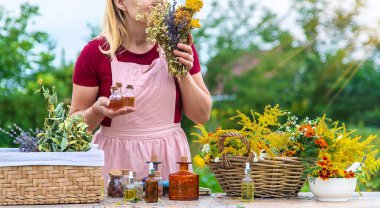 Woman with medicinal herbs and tinctures. Selective focus. Nature.