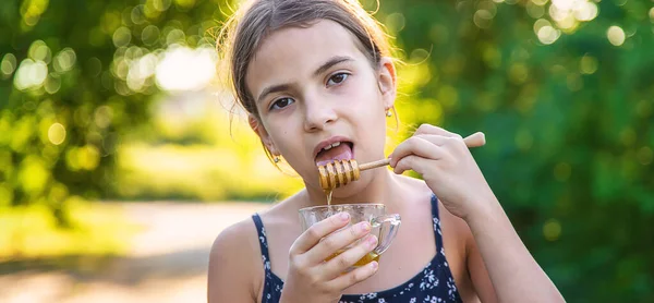 Child Eats Honey Park Selective Focus Kid — стоковое фото