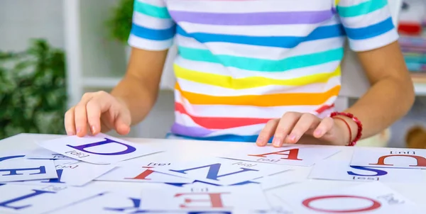 The child learns English letters. Selective focus. Kid.