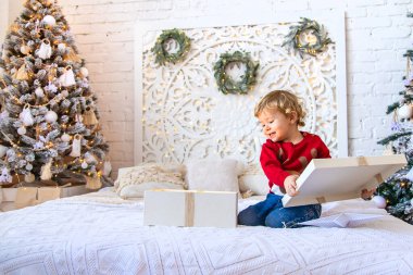 Çocuk ağacın altındaki Noel hediyelerini açar. Seçici odaklanma. Çocuk.