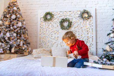 Çocuk ağacın altındaki Noel hediyelerini açar. Seçici odaklanma. Çocuk.