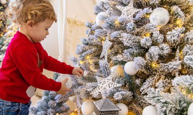 Çocuk Noel ağacına bir süs astı. Seçici odaklanma. Çocuk.