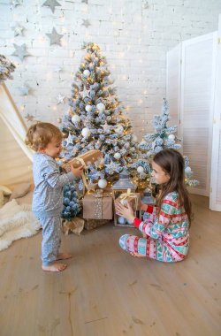Çocuk ağacın altındaki Noel hediyelerini açar. Seçici odaklanma. Çocuk.
