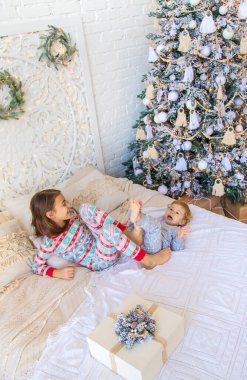 Çocuklar Noel ağacının yanındaki yatakta zıplıyorlar. Seçici odaklanma. çocuk.
