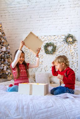 Çocuklar ağacın altındaki Noel hediyelerini açarlar. Seçici odaklanma. Çocuk.