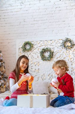 Çocuklar ağacın altındaki Noel hediyelerini açarlar. Seçici odaklanma. Çocuk.