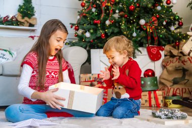 Çocuklar ağacın altındaki Noel hediyelerini açarlar. Seçici odaklanma. Çocuk.