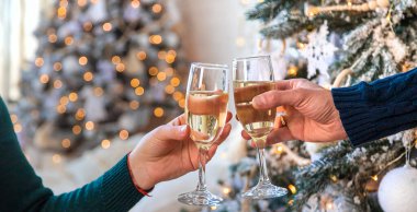 Man and woman with champagne in their hands near the Christmas tree. Selective focus. Couple. clipart