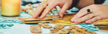 Bir falcı tarot kartlarıyla okur. Seçici odaklanma. Kadın.