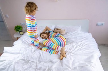 Çocuklar yatakta zıplama oynarlar. Seçici odaklanma. Çocuk.