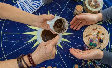 Bir falcı kahve telvesinde fal bakar. Seçici odaklanma. Kadın.