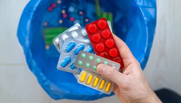 Tabletleri çöpe at. Seçici odaklanma. Mavi.