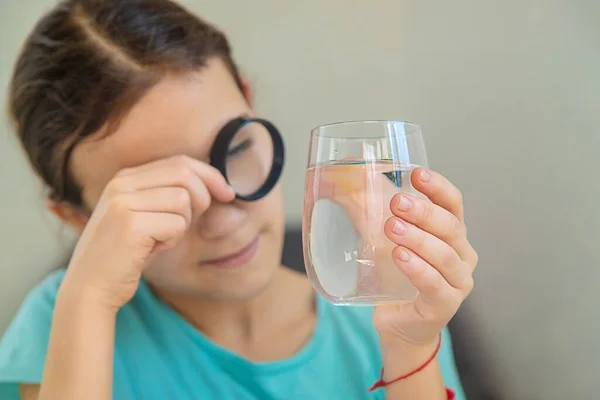子供は虫眼鏡の下で水を調べる 選択的フォーカス キッド — ストック写真